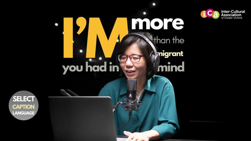 A woman wearing headphones and glasses speaks into a microphone, in front of a laptop, with text overlaid on a black background that says "I'm more than the immigrant you had in mind".