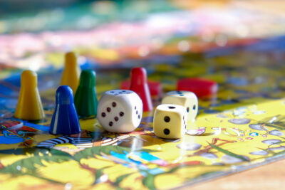 Game pieces and dice scattered on a colorful board game, ready for play.