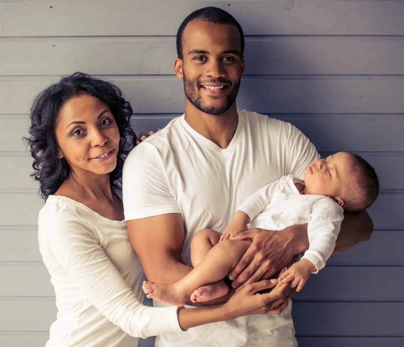 happy-family-portrait-with-infant-against- Two joyful children with arms around each other on a playground, with trees in the background.